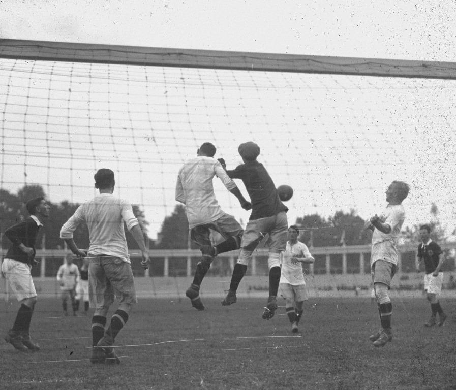 Sfeerbeeld voetbalmatch Olympische Spelen 1920: keeper en veldspeler springen naar bal