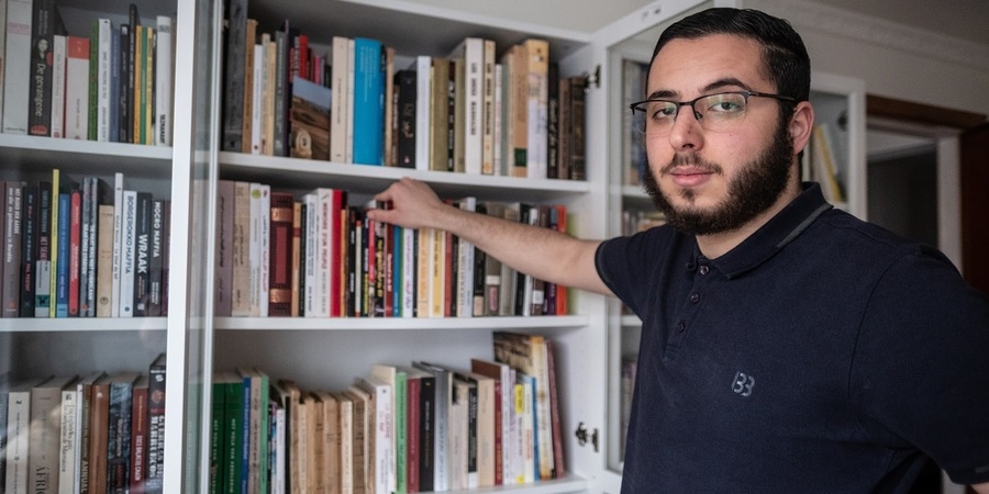 man toont boekenkast