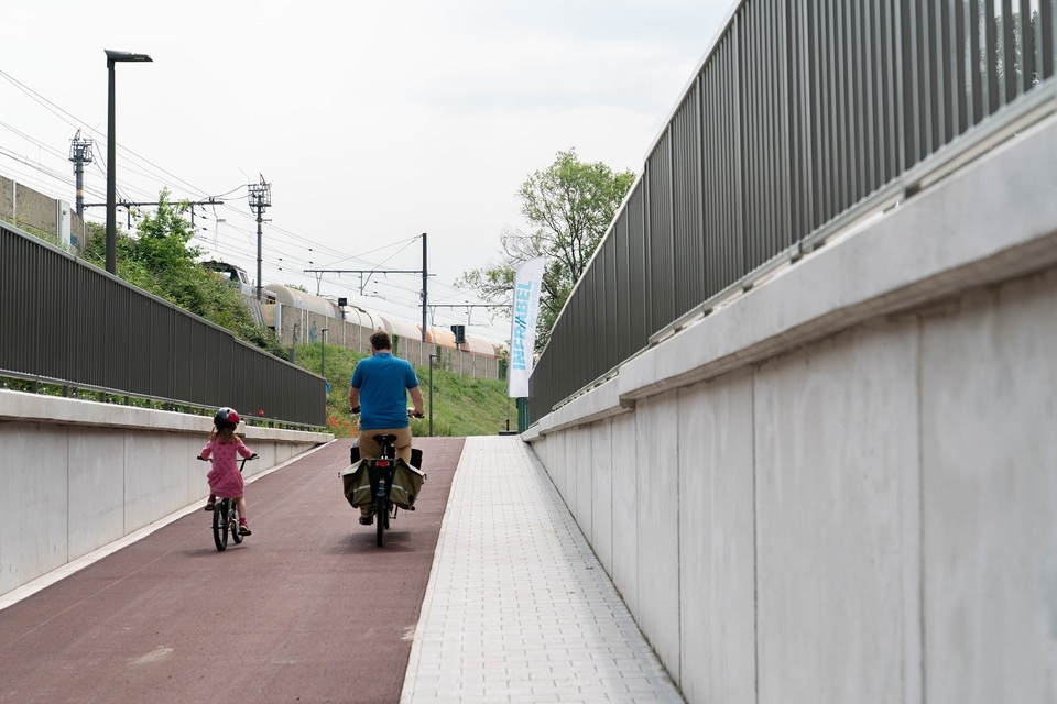 Vader en dochter fietsen de fietstunnel uit richting Bist.