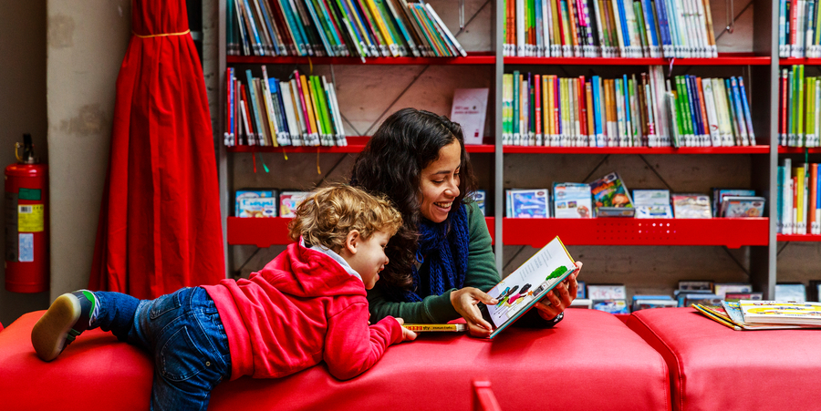 Een vrouw en kind lezen samen in een kinderboek Een vrouw en kind lezen samen in een kinderboek