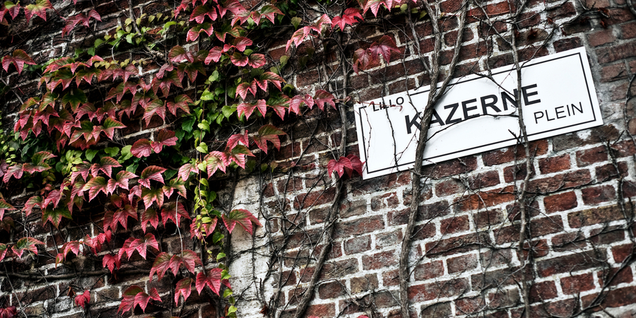 Een straatnaambord tegen een muur in Lillo: Kazerneplein. Een straatnaambord tegen een muur in Lillo: Kazerneplein.