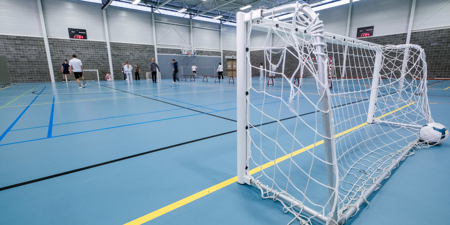Zicht op sporthal met in de achtergrond sportende studenten Zicht op sporthal met in de achtergrond sportende studenten