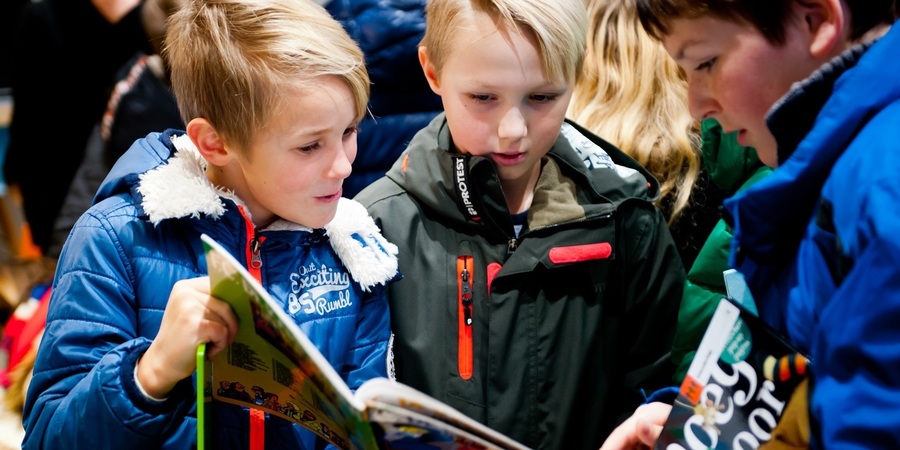Leerlingen bekijken boeken in de bibbus Leerlingen bekijken boeken in de bibbus