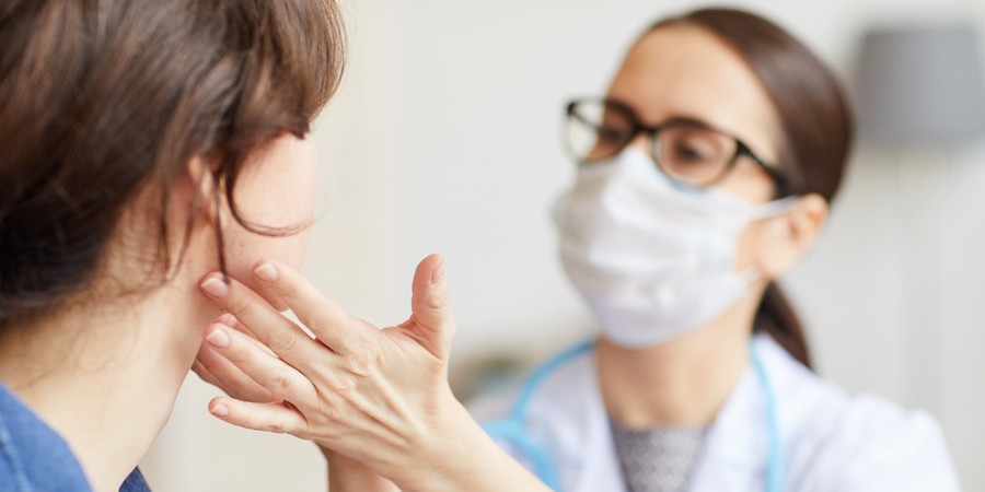 Huisdokter voelt aan keel van patiënt Huisdokter voelt aan keel van patiënt