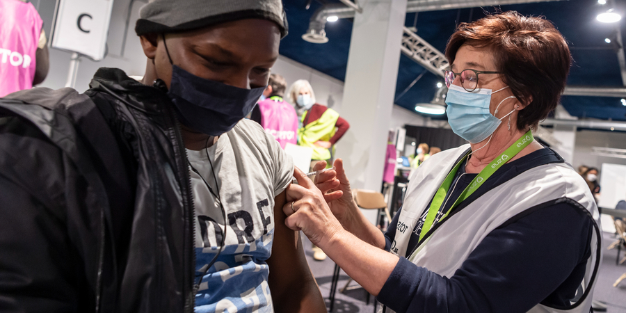 Man krijgt vaccin in de bovenarm. Man krijgt vaccin in de bovenarm.