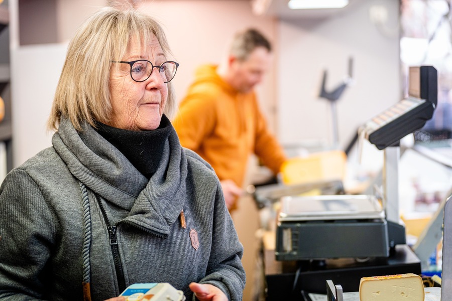 De mama van Ive achter de kassa