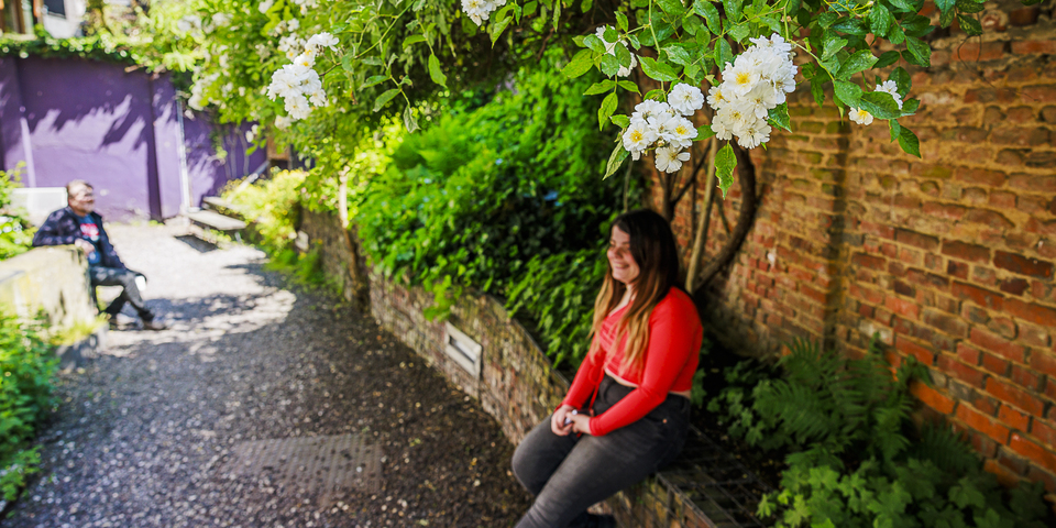 Mensen genieten van bloemen en koelte in een zonnige tuin