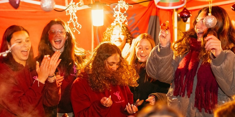 Een aantal meisjes in feeststemming onder een rode tent Een aantal meisjes in feeststemming onder een rode tent