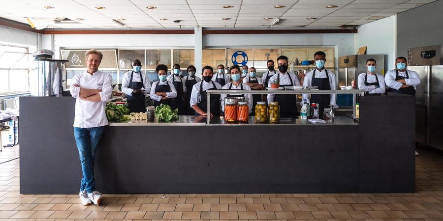Chef-kok Seppe Nobels poseert met zijn team in een restaurant. Chef-kok Seppe Nobels poseert met zijn team in een restaurant.