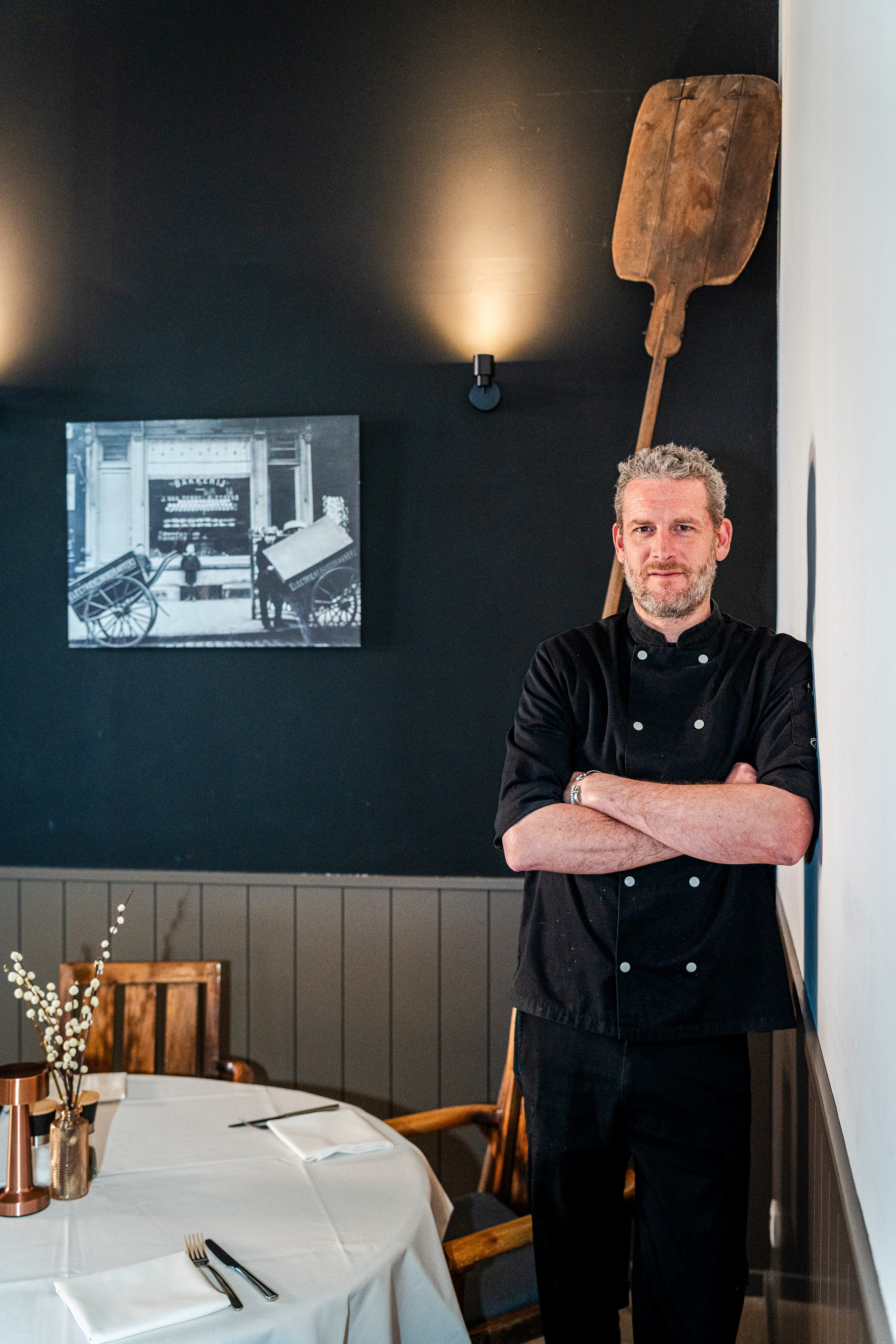 Pieter poseert in de hoek van zijn restaurant