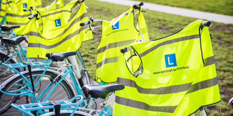 Een rij fietsen van de Fietsschool met fluohesjes