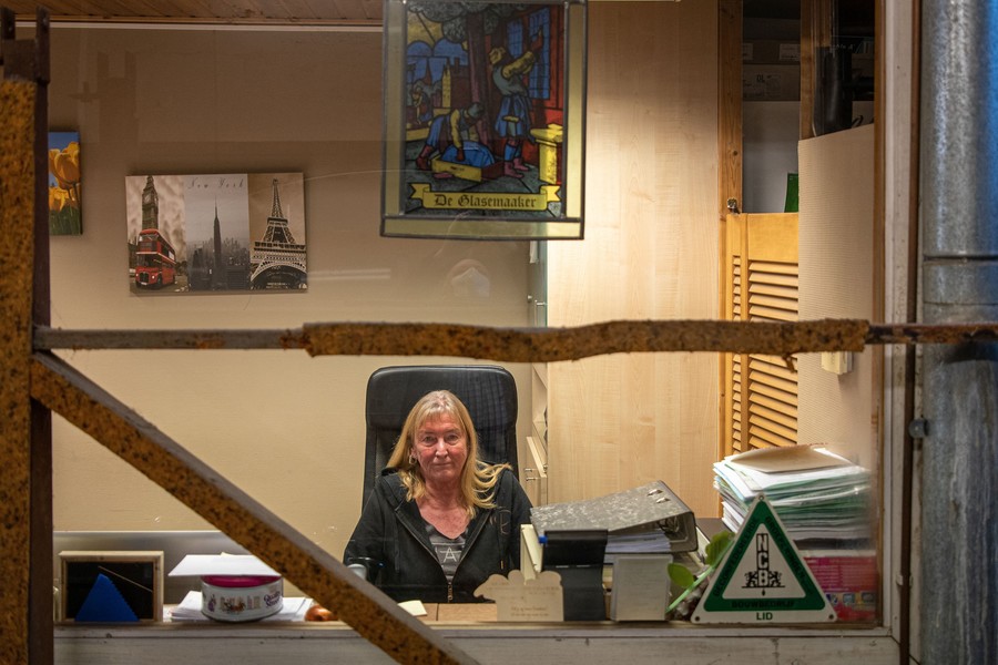 Vrouw zit achter bureau aan het onthaal Vrouw zit achter bureau aan het onthaal