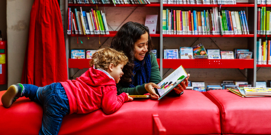 Een vrouw helpt een kindje bij het lezen Een vrouw helpt een kindje bij het lezen