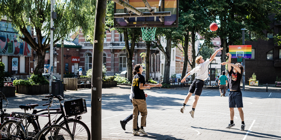 Jongeren die aan het basketten zijn op veldje op de Sint-Andriesplaats Jongeren die aan het basketten zijn op veldje op de Sint-Andriesplaats
