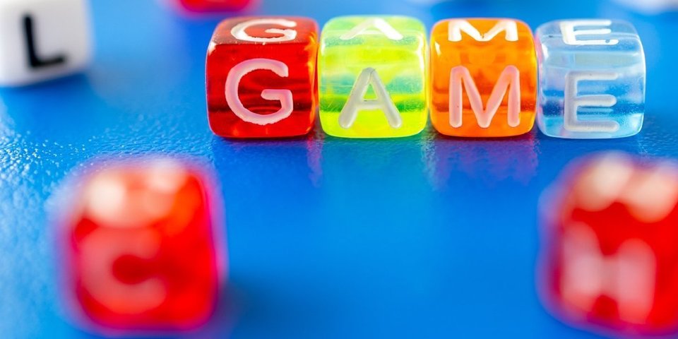 Dobbelstenen die het woord 'GAME' vormen.