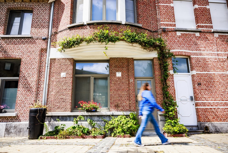 Wandelaar die voorbij een geveltuin wandelt.