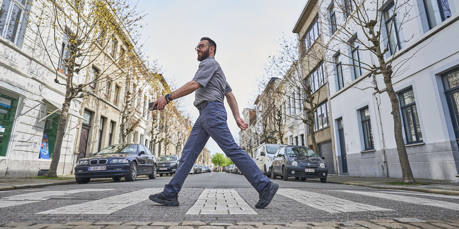 Een parkeerwachter steekt de straat over Een parkeerwachter steekt de straat over