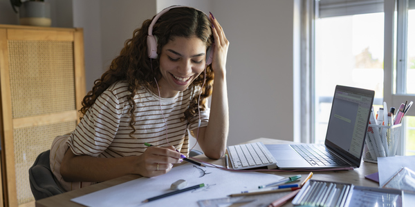Een jongedame tekent terwijl ze naar muziek luistert