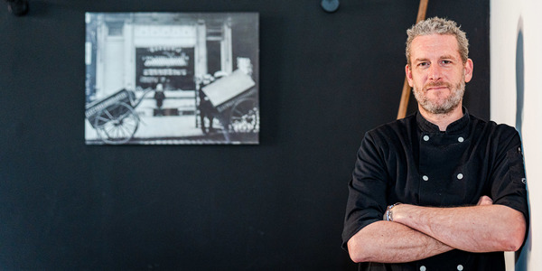 Pieter poseert in de hoek van zijn restaurant