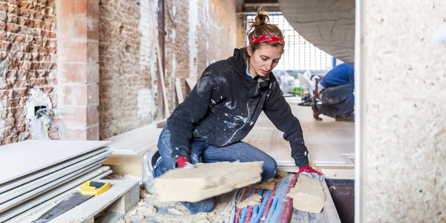 Een vrouw isoleert de vloer van haar huis Een vrouw isoleert de vloer van haar huis