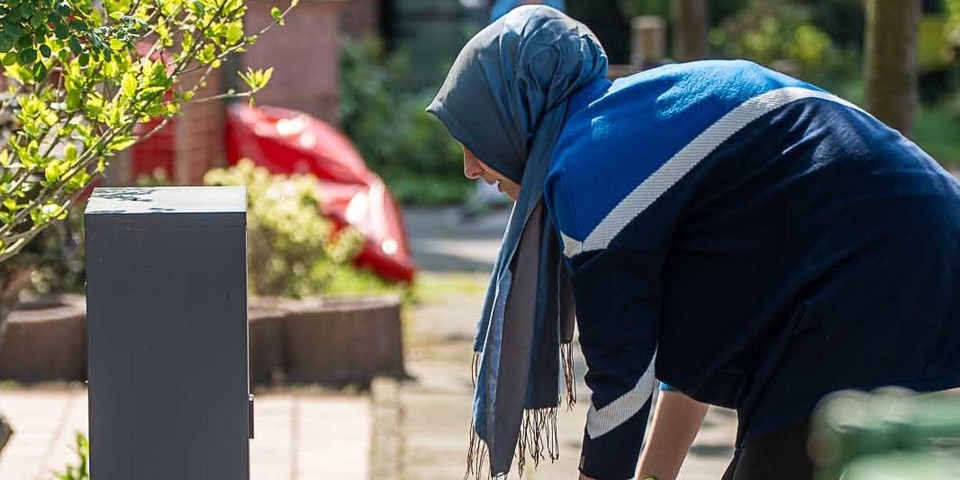 Vrouw is haar voortuin aan het poetsen Vrouw is haar voortuin aan het poetsen