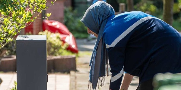 Vrouw is haar voortuin aan het poetsen