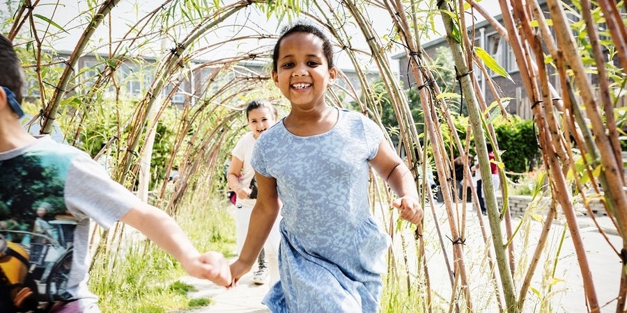 Kinderen lopen door een wilgentunnel in SB De Piramide Kinderen lopen door een wilgentunnel in SB De Piramide