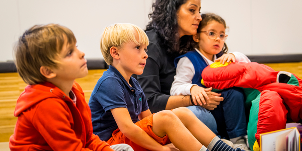 Kinderen en ouder luisteren naar een vertelling.