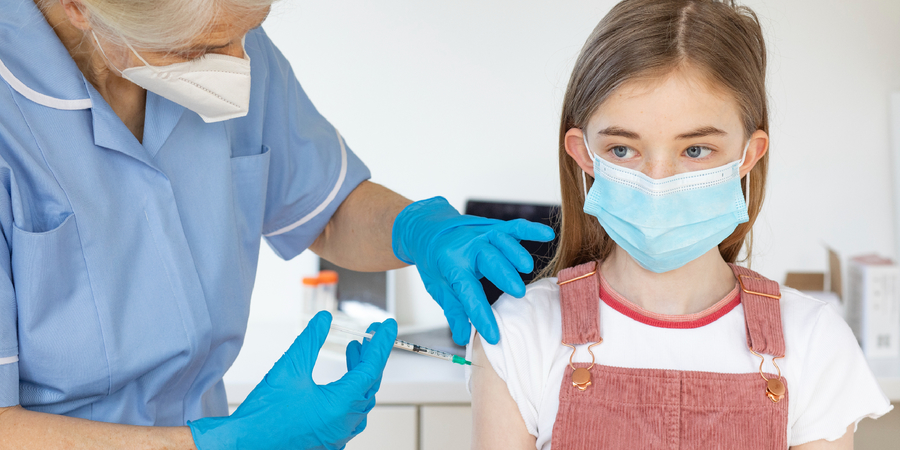 Kind krijgt vaccin in bovenarm Kind krijgt vaccin in bovenarm