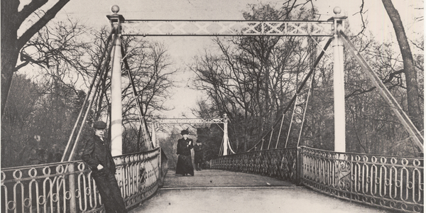 Wandelaars op de hangbrug in het stadspark in 1906.