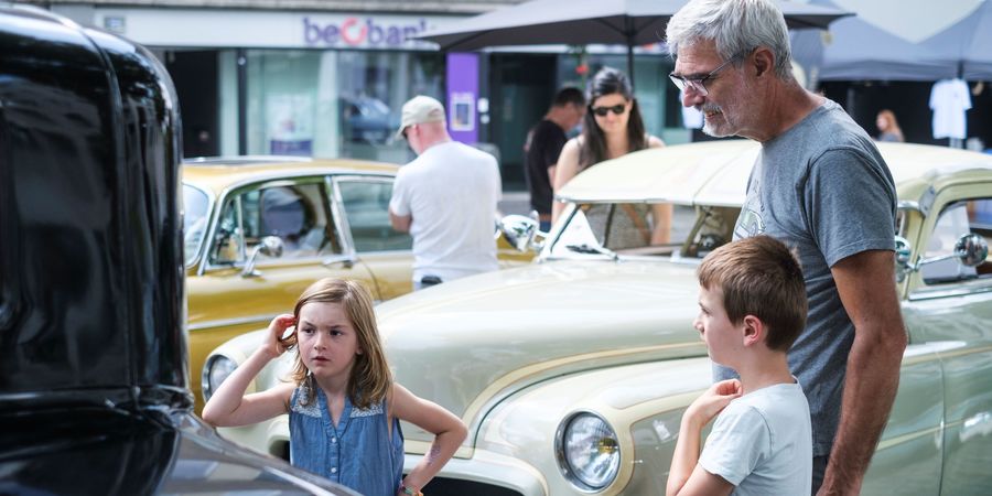 Enkele bezoekers van de jaarmarkt bekijken oldtimers tijdens de Janny Engels Memorial