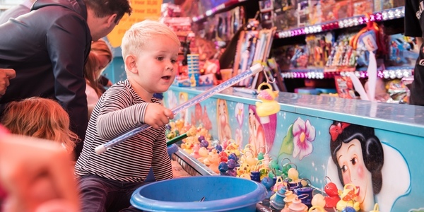 Een kind vist eendjes op een kermisattractie op de jaarmarkt van 2018.