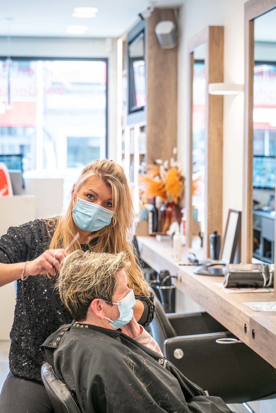 Kapster is het haar van een vrouw aan het knippen