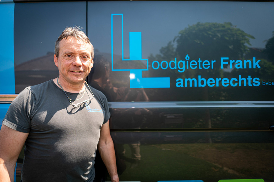 Frank Lamberechts poseert voor zijn camionet waarop zijn logo staat