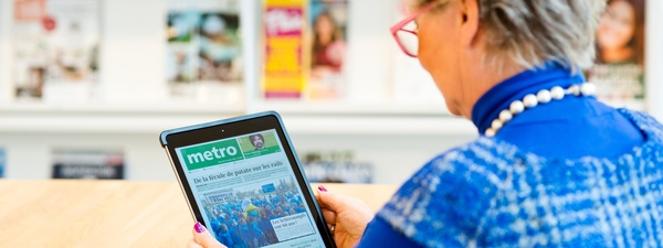 Vrouw leest Metro op tablet in Bibliotheek Bist Vrouw leest Metro op tablet in Bibliotheek Bist