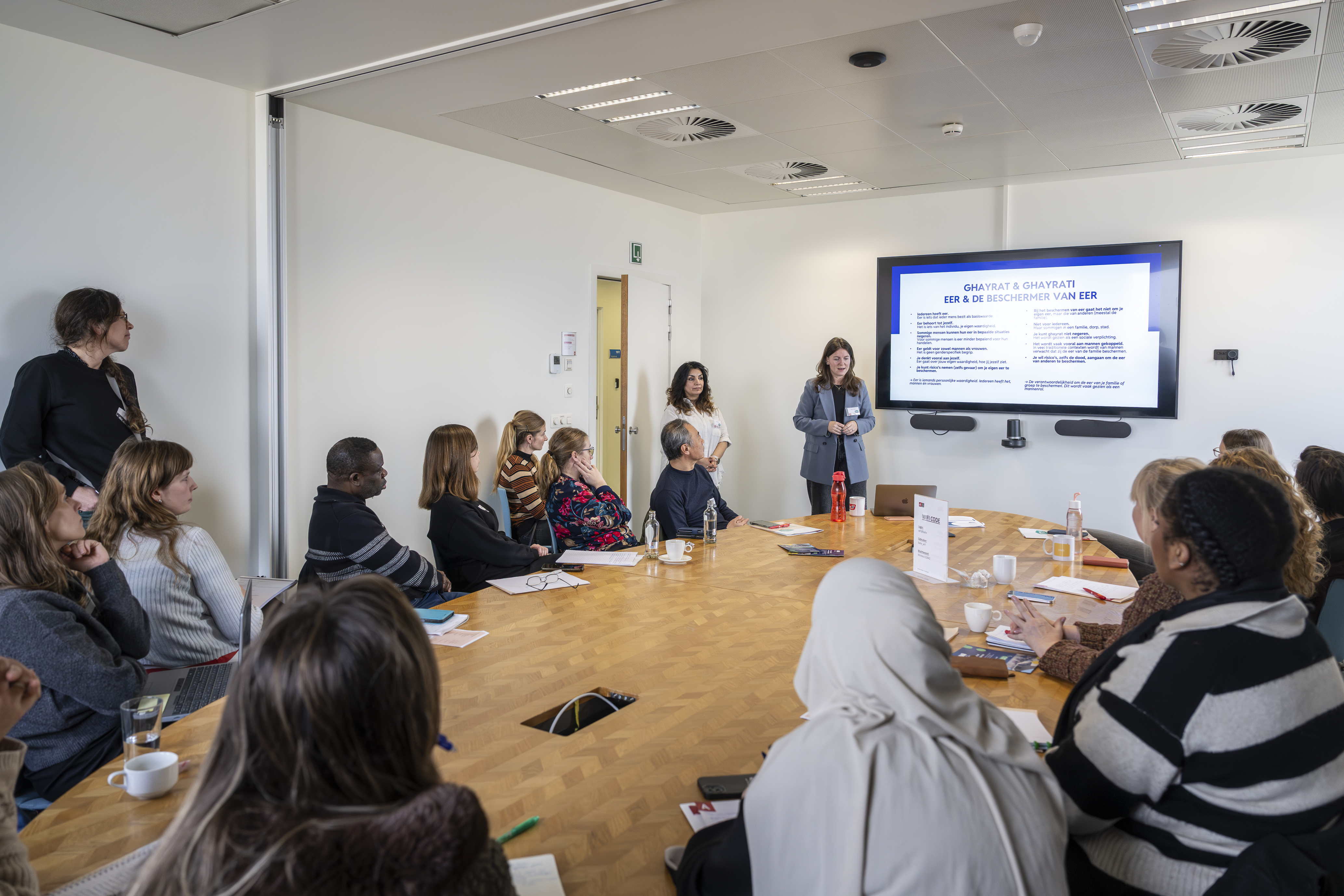 Mensen zitten rond tafel in vergaderzaal