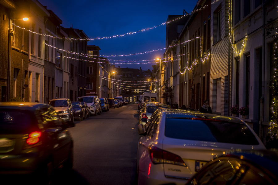 Berchemse straat in de schemer, versierd met lichtslingers