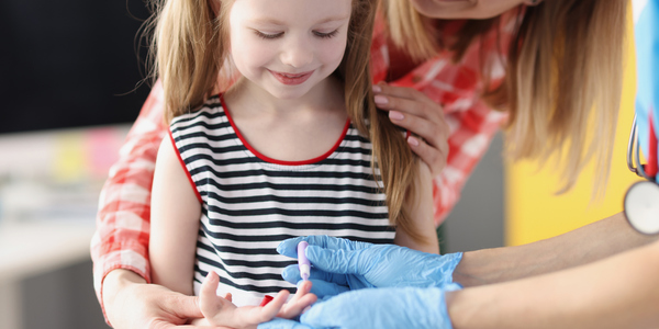 Een kindje wordt geprikt in de vinger. Zo wordt bloed afgenomen voor het bloedonderzoek.