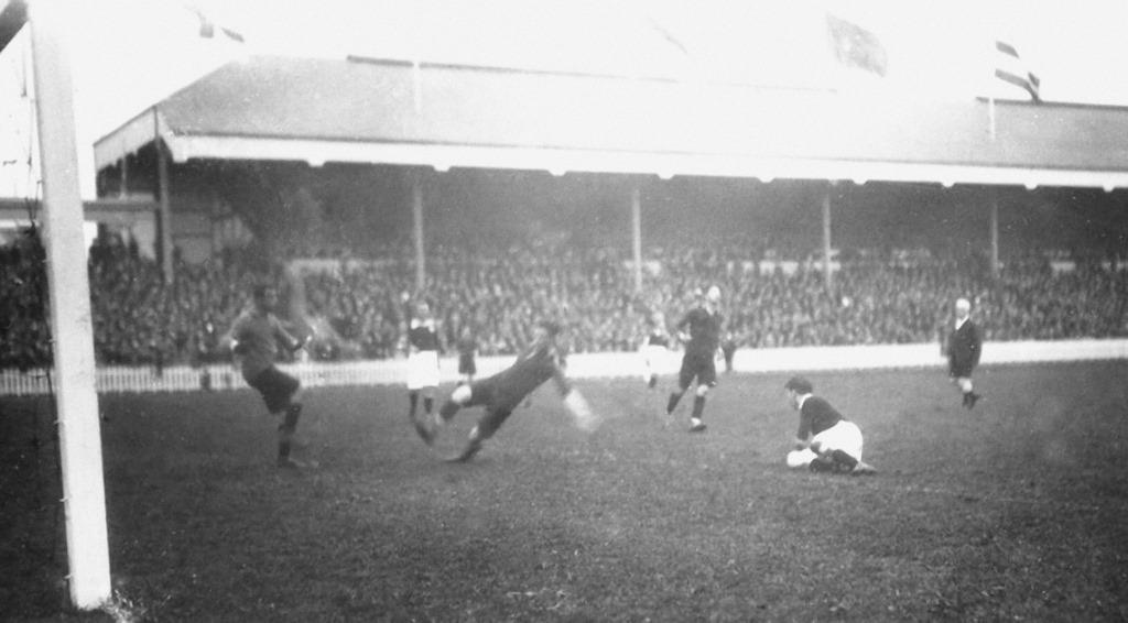 Sfeerbeeld voetbalmatch Olympische Spelen 1920: 6 spelers waarvan 1 op doel schiet