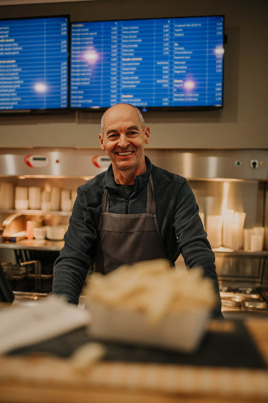 Frietjes in de frituur en Tony achter de toog