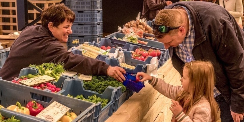 Vrouw geeft tomaat aan kind