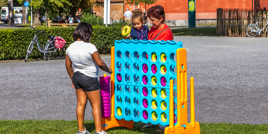 Een familie speelt met een reuze 4 op een rij-spel Een familie speelt met een reuze 4 op een rij-spel