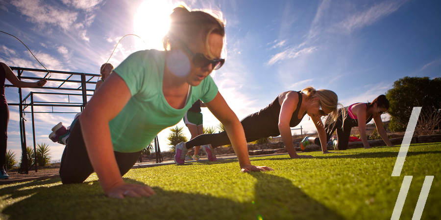 Een groepje vrouwen staat in pomphouding op een grasveld