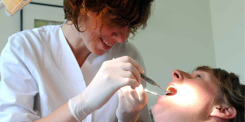 Een vrouw op consultatie bij een tandarts.