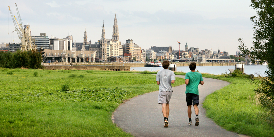2 mannen joggen met de Antwerpse skyline op de achtergrond 2 mannen joggen met de Antwerpse skyline op de achtergrond
