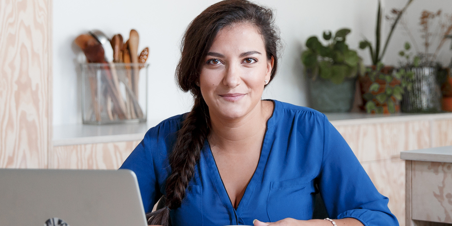 Een vrouw werkt aan de computer en kijkt in de camera. Een vrouw werkt aan de computer en kijkt in de camera.