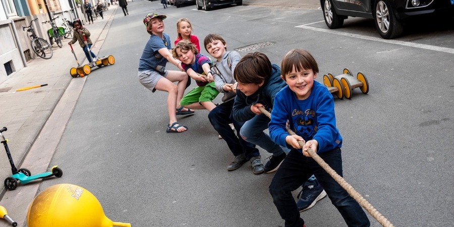 Foto van kinderen die touwtrekken in een speelstraat Foto van kinderen die touwtrekken in een speelstraat