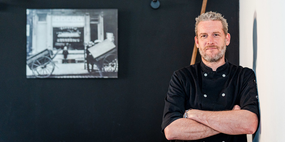 Pieter poseert de hoek van zijn restaurant
