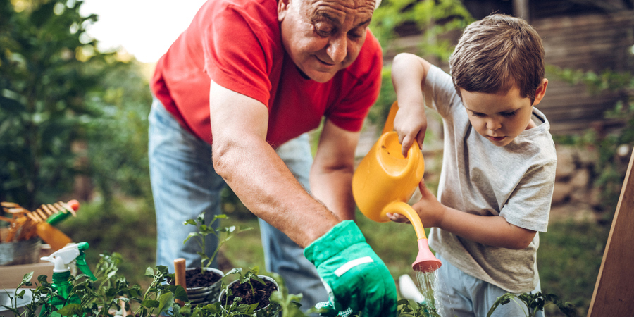 oudere man en kleine jongen werken samen in de tuin