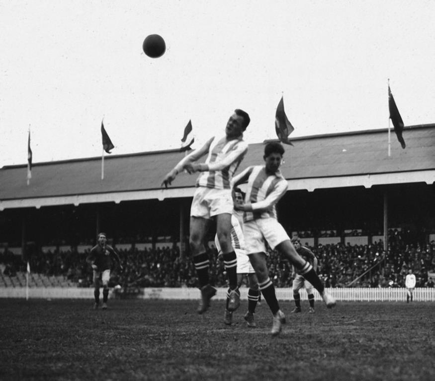 Sfeerbeeld voetbalmatch Olympische Spelen 1920: kopbalduel tussen 2 spelers